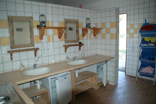 une salle de bain avec deux lavabos et deux miroirs dans l'établissement camping roussel, à Saint-Paul-dʼEspis