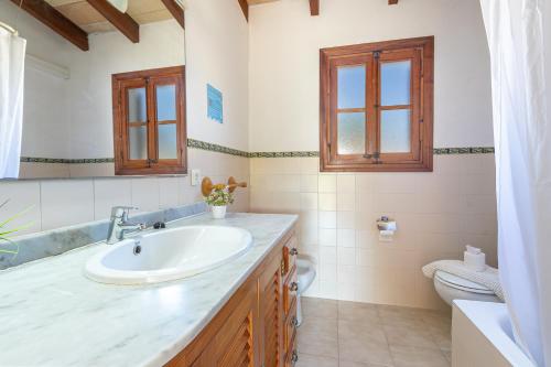 a bathroom with a sink and a toilet at Villa Ca Na Magdalena By homevillas360 in Pollença