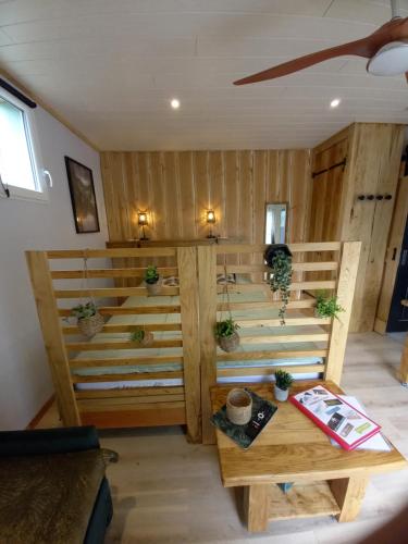 a room with a wooden wall with potted plants at Le cabanon in Le Massegros