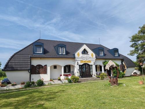 a large white house with a black roof at Gedeon Tanya Panzió in Jakabszállás