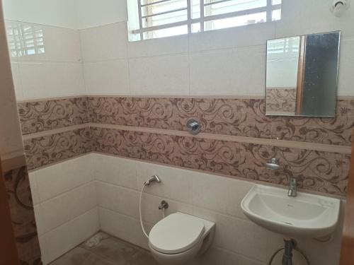 a bathroom with a toilet and a sink at Royal Home Stay Mysuru - Service Apartment in Mysore