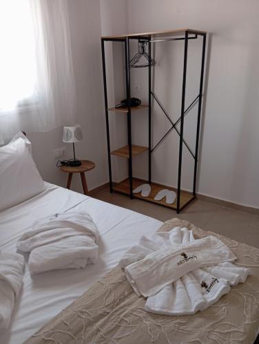 a bed with white towels sitting on top of it at ARTEMIS beach studios in Kalamaki Heraklion