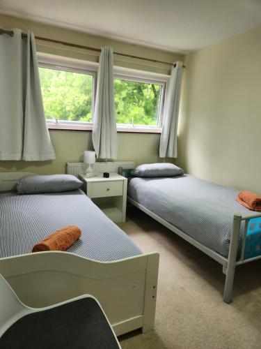 two beds in a bedroom with two windows at Twin Room in Crawley,Gatwick,West Sussex in Ifield