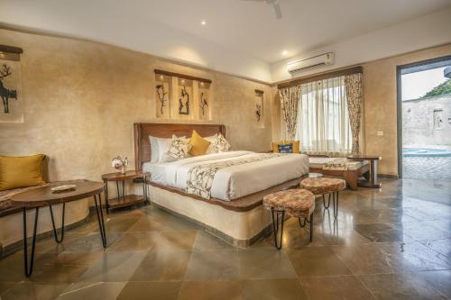 a hotel room with a bed and a table and chairs at Maya Luxury J Wild Resort Jawai in Dhrubana