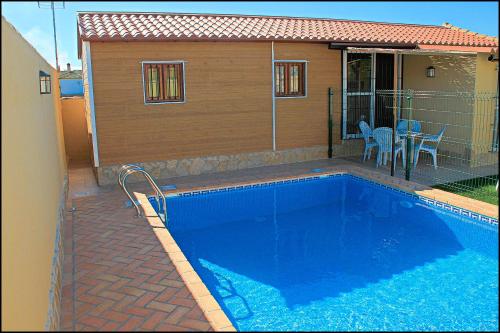 ein Swimmingpool vor einem Haus in der Unterkunft Bungalow Curro Pareja 131 in Conil de la Frontera