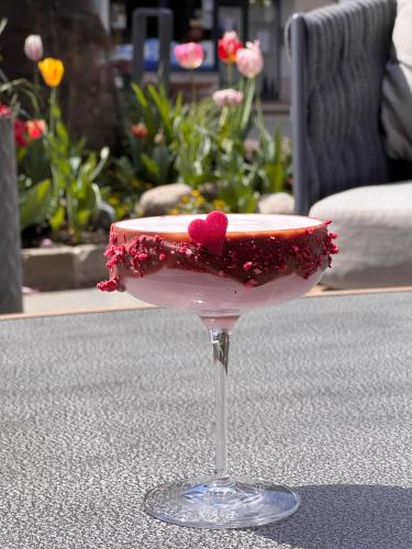 a drink with a red heart on a table at Alpin & Wellness Resort Ludwig Royal in Oberstaufen