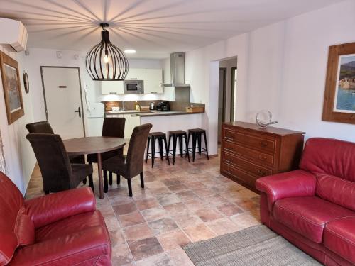 un salon avec un canapé rouge et une table dans l'établissement Superbe T2 60m2 classé 5 étoiles, quartier des peintres, calme, plages à pied, climatisation, wifi, à Collioure