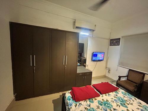 a bedroom with a bed and a cabinet with red pillows at Green rooms in Bhopal