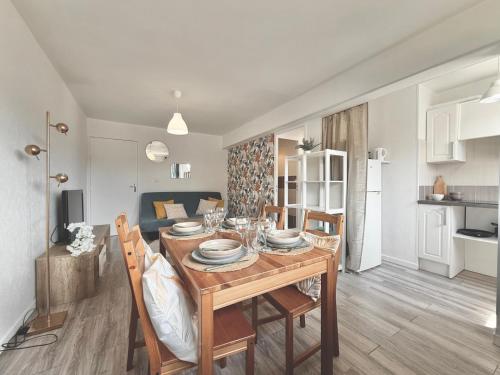 - une table à manger et des chaises dans le salon dans l'établissement Charmant T3, Parking & Wi-fi, Cuisine équipée, à Villers-sur-Mer