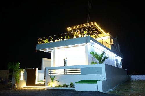 a white building with lights on it at night at Sun Splash Villa in Chīrāla