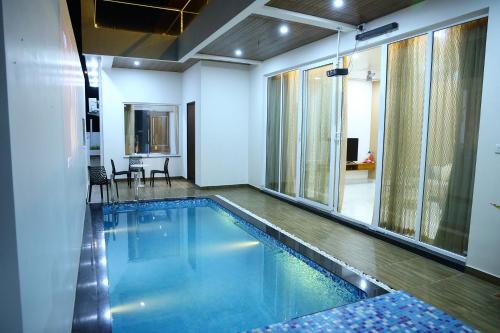 a swimming pool in a room with a table and chairs at Sun Splash Villa in Chīrāla