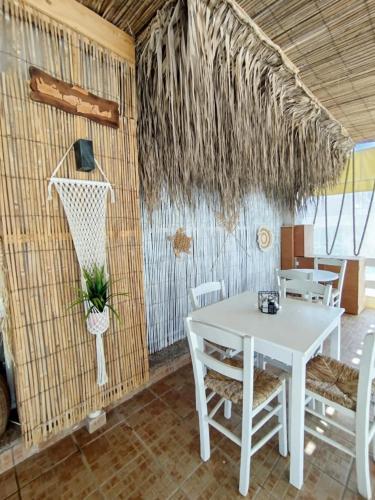 a dining room with a white table and a basketball hoop at ARTEMIS beach studios in Kalamaki Heraklion