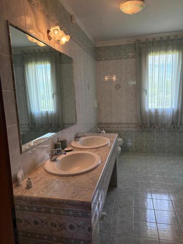 a bathroom with two sinks and a large mirror at La Brentella in Arzergrande