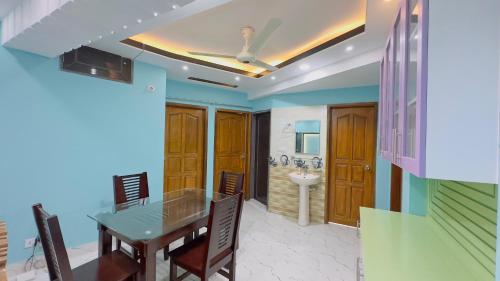 a dining room with a table and a bathroom at Baridhara Sweet Home in Dhaka