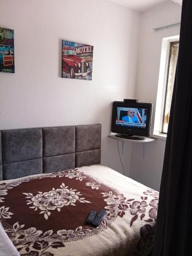 a bedroom with a bed and a tv in it at Cozzy Studio Flat in Tirana