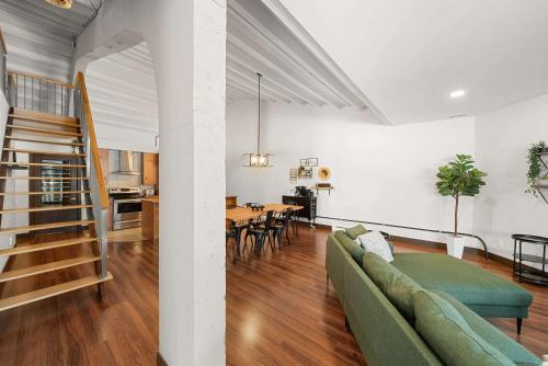 a living room with a green couch and a dining room at Detente au bord du fleuve - Condo in Chateau Richer