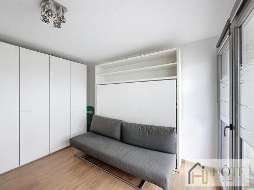 un salon avec un canapé et une fenêtre dans l'établissement L'Écume Douce - Sea View & Charm, à Bray-Dunes