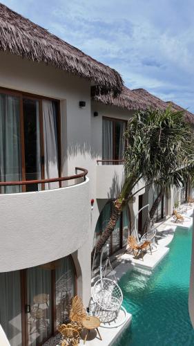 a resort with a swimming pool next to a building at La Mer Bali Mui Ne in Phan Thiet