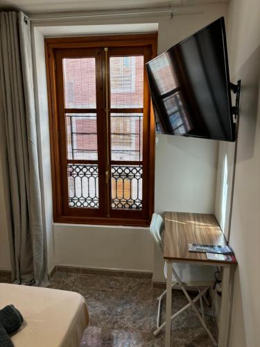 a room with a television and a window at Magnífica habitación con baño privado in Valencia