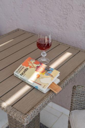 ein Buch und ein Glas Wein auf dem Tisch in der Unterkunft Endless Blue Seaside View in Plakias