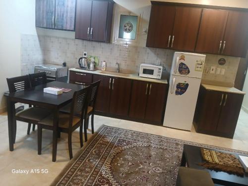 una cocina con una mesa y un refrigerador en العييري للشقق المخدومة الدمام 3, en Dammam