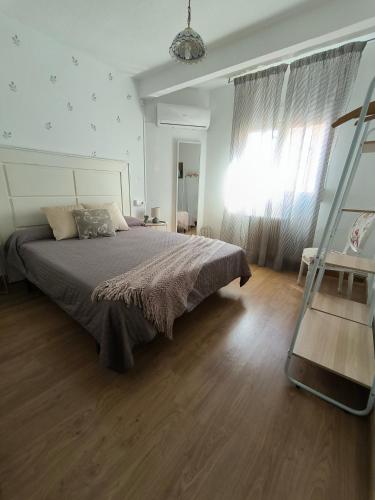 a bedroom with a large bed and a wooden floor at Vivienda La Manola in Daimiel