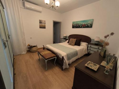 a bedroom with a bed and a table and a desk at Vivienda La Manola in Daimiel