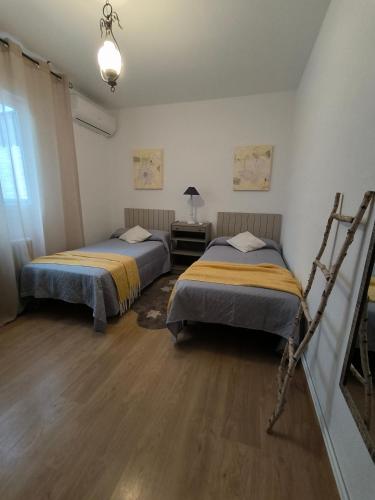 a room with two beds and a table with a lamp at Vivienda La Manola in Daimiel