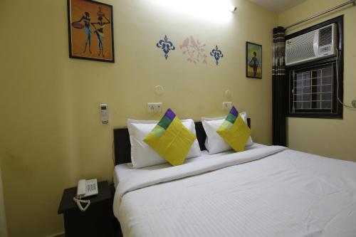 a bedroom with a bed with pillows and a phone at Hotel Satyam Swagat in Jawālāpur
