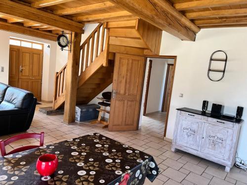 un salon avec un canapé et un escalier dans l'établissement Albizia, à Sainte-Geneviève