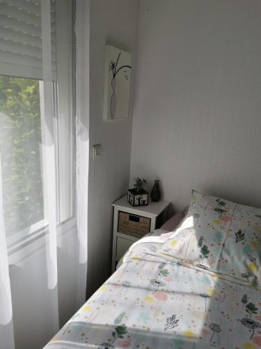 une chambre avec un lit avec une couette et une fenêtre dans l'établissement Chambre Indépendante 