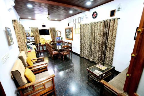 a living room with a couch and chairs and a table at Beena Homestay in Fort Kochi