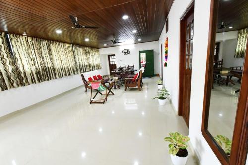 a living room with chairs and tables in a building at Beena Homestay in Fort Kochi