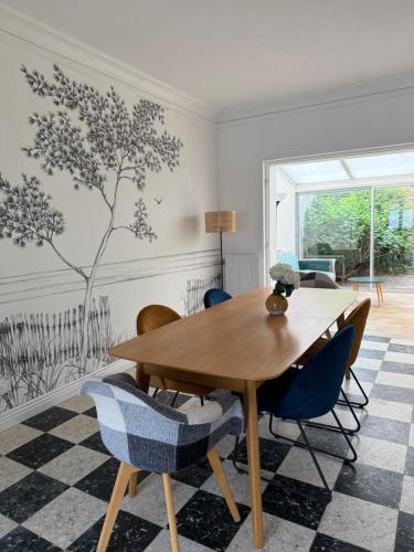a dining room with a wooden table and chairs at Villa Malo Étoile proche de la mer in Dunkerque