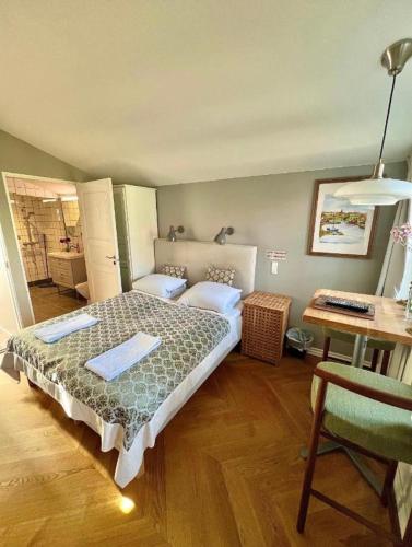 a bedroom with a bed and a desk and a desk at Villa Wiegand - a room with a view in Holbæk