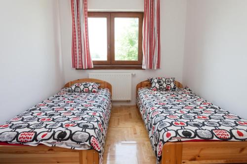 two twin beds in a room with a window at Gedeon Tanya Panzió in Jakabszállás
