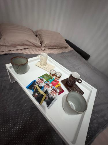 - une table blanche avec un plateau de nourriture sur un lit dans l'établissement Studio cosy Le Vismara, à Nice