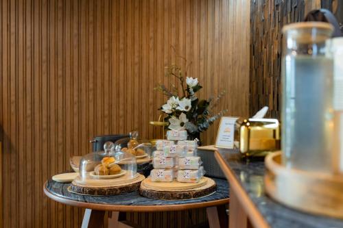 a table with a cake and a vase of flowers at Mybed Gold Chonburi in Ban Lang Khao