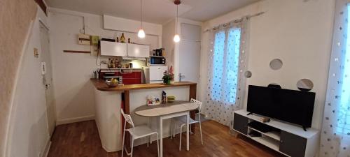 une petite cuisine avec une petite table et une télévision dans l'établissement Appart Duplex MontSouris Paris14, à Paris