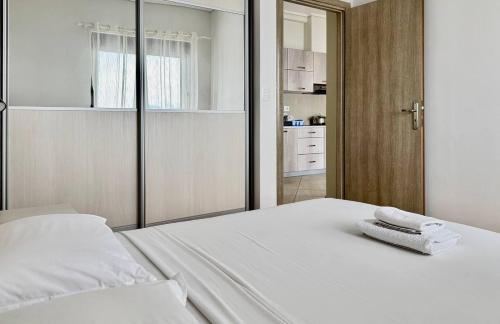 Un dormitorio con una cama blanca con dos toallas encima. en Plutus Sea View Apartment, en Sarandë
