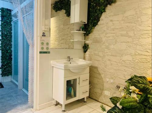 a bathroom with a sink and a stone wall at Nice room less pay near Port Adelaide in Rosewater