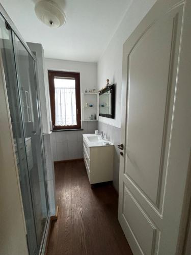 a bathroom with a sink and a glass door at Ca Belvedere in Follo Alto