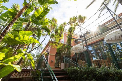 a house with palm trees in front of it at Hotel MR Les Rotes in Denia