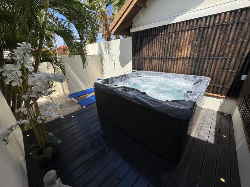 a hot tub sitting on top of a wooden deck at Boutique Hotel Swiss Paradise Aruba Villas and Suites in Palm-Eagle Beach