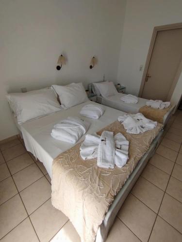two beds with towels on them in a room at ARTEMIS beach studios in Kalamaki Heraklion