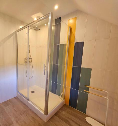 une douche avec une porte vitrée dans une salle de bain dans l'établissement Pause détente dans Le Vieux Deauville, à Deauville