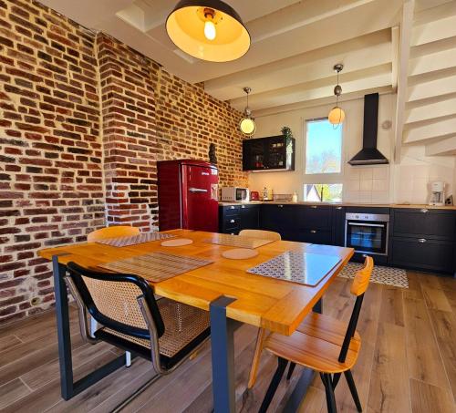 une cuisine avec une table en bois et un mur en briques dans l'établissement Pause détente dans Le Vieux Deauville, à Deauville