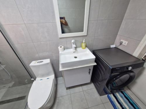 a bathroom with a white toilet and a sink at Mountain View Retreat in Flic-en-Flac