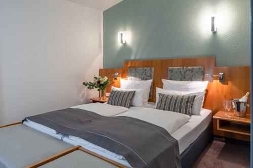 a bedroom with a large bed with white sheets and pillows at Residenz Hotel Detmold in Detmold