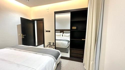 a bedroom with a bed and a large mirror at شركة المكان الأفضل للخدمات الفندقية in Al Aqiq